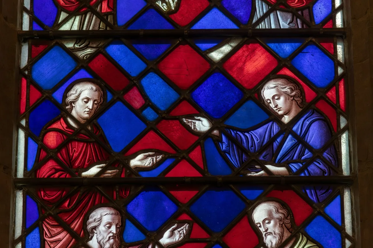 Détail d'un vitrail savoyard montrant le réseau de plomb et la peinture à la grisaille sur le verre coloré